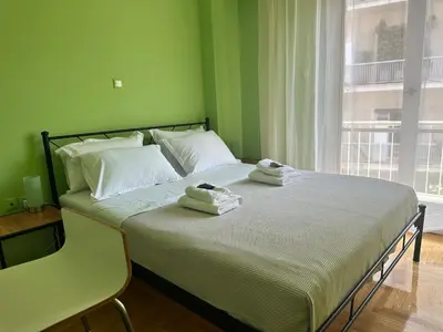 a green bedroom with a bed with towels on it at Urban Acropolis Apartment With Fast internet in Athens
