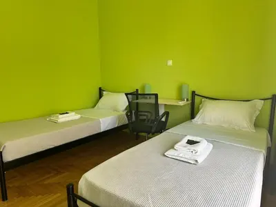 two beds in a room with a green wall at Urban Acropolis Apartment With Fast internet in Athens