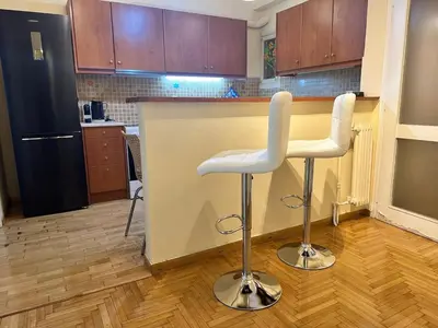 a kitchen with two white bar stools in front of a counter at Urban Acropolis Apartment With Fast internet in Athens