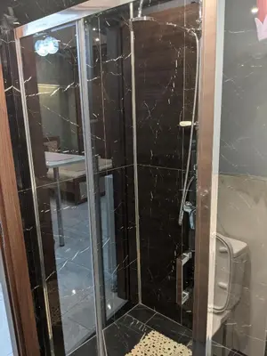 a bathroom with a glass shower with a toilet at Athens Kallithea Apartment in Athens