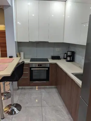 a kitchen with white cabinets and a stove top oven at Athens Kallithea Apartment in Athens