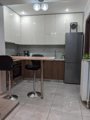 a kitchen with a table and a refrigerator at Athens Kallithea Apartment in Athens