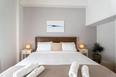 a bedroom with a bed with two pairs of white towels at 1400ft Central Rooftop Gym King Bed WFH in Athens