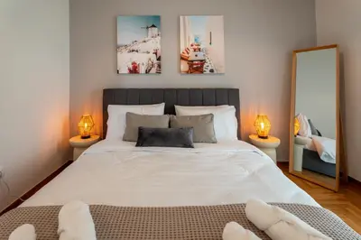 a bedroom with a large white bed with two lamps at 1400ft Central Rooftop Gym King Bed WFH in Athens