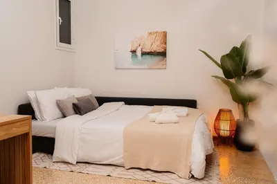 a bedroom with a bed with white sheets and a table at 1400ft Central Rooftop Gym King Bed WFH in Athens