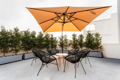 a table and chairs with an umbrella on a patio at 1400ft Central Rooftop Gym King Bed WFH in Athens