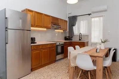 a kitchen with a table and a stainless steel refrigerator at 1400ft Central Rooftop Gym King Bed WFH in Athens