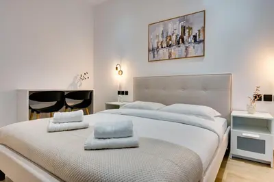 a white bedroom with two beds with towels on them at CityLife apartment 2'from metaxourgio station 2B in Athens