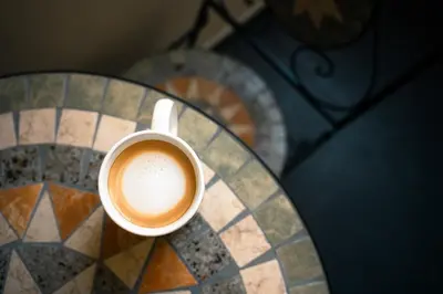 a cup of coffee sitting on a glass table at CityLife apartment 2'from metaxourgio station 2B in Athens
