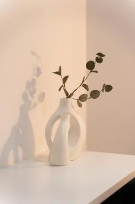 a white vase with a plant in it on a table at CityLife apartment 2'from metaxourgio station 2B in Athens