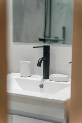 a sink with a faucet and a cup on it at CityLife studio 2'from metaxourgio station 2A in Mesochórion