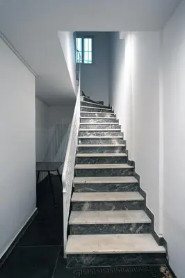 a staircase with wooden steps in a building with a window at CityLife studio 2'from metaxourgio station 2A in Mesochórion