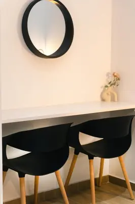 a table with two black chairs and a mirror at CityLife studio 2'from metaxourgio station 2A in Mesochórion