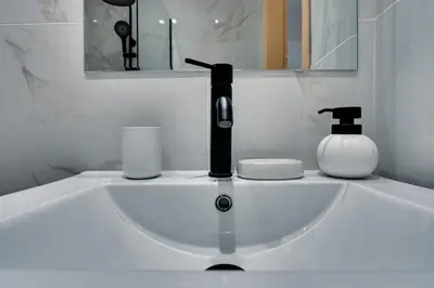 a bathroom sink with a soap dispenser on it at CityLife studio 2'from metaxourgio station 2A in Mesochórion