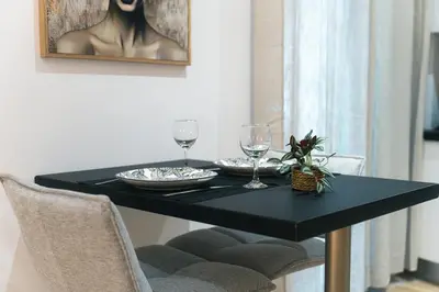a black dining table with two wine glasses on it at CityLife studio 2'from metaxourgio station 2A in Mesochórion