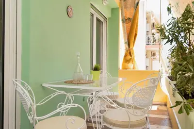 a table and chairs in a room with green walls at PS Apartment in Athens