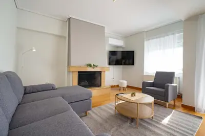 a living room with a couch and a fireplace at Sunlit Terrace 3BR Apartment - Tavros by ΜΡS in Athens