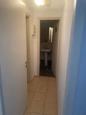 a hallway leading to a bathroom with a sink at 45 τμ διαμέρισμα in Athens