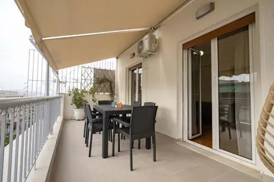 a balcony with a black table and chairs on it at Kypseli Pulse 2BR Residence by ΜΡS in Athens