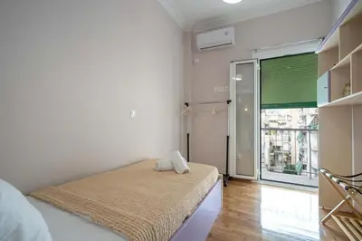 a bedroom with a bed and a large window at Kypseli Pulse 2BR Residence by ΜΡS in Athens