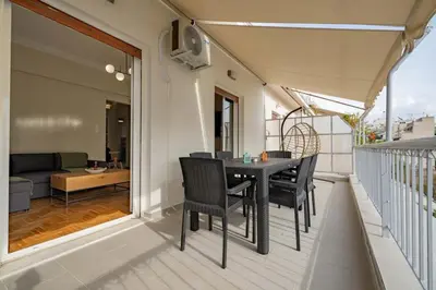 a balcony with a table and chairs and a couch at Kypseli Pulse 2BR Residence by ΜΡS in Athens