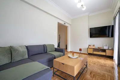 a living room with a blue couch and a table at Kypseli Pulse 2BR Residence by ΜΡS in Athens