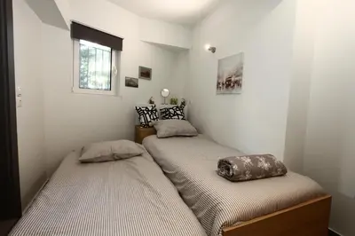 two twin beds in a room with white walls at Harmonia in Athens