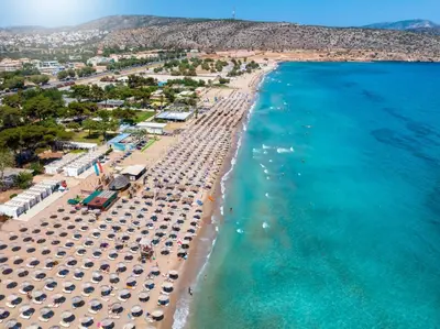 an aerial view of a beach with umbrellas and the ocean at Harmonia in Athens