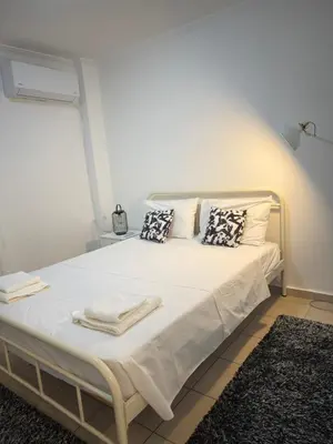 a white bed with towels on it in a room at New Place Athens in Athens