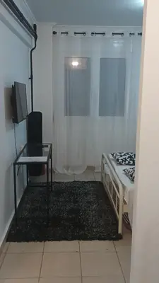 a bedroom with a bed and a table and a television at New Place Athens in Athens
