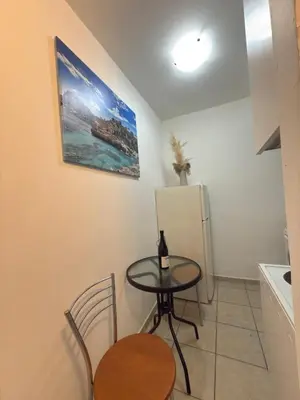 a small kitchen with a table and a refrigerator at New Place Athens in Athens