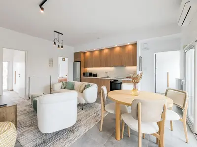 a kitchen and living room with a table and chairs at Acropolis view 2BD top floor next to tram and port in Piraeus