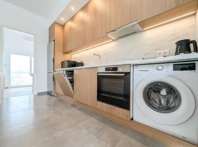 a kitchen with a washing machine in a kitchen at Acropolis view 2BD top floor next to tram and port in Piraeus