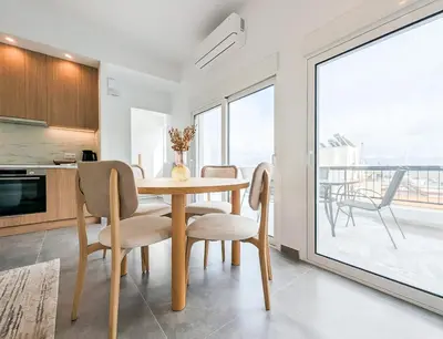a kitchen and dining room with a table and chairs at Acropolis view 2BD top floor next to tram and port in Piraeus