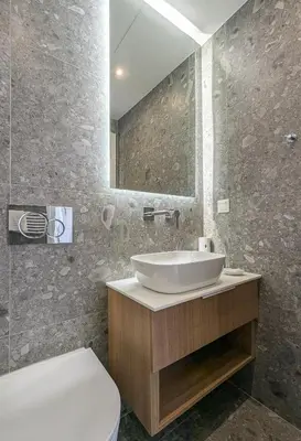 a bathroom with a sink and a toilet and a mirror at Acropolis view 2BD top floor next to tram and port in Piraeus