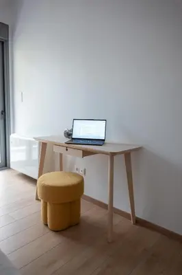 a laptop computer sitting on a wooden desk with a stool at Bright Urban Retreat in Athens in Athens