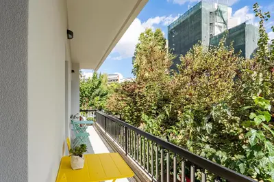 a balcony with a yellow table and some trees at Bright Urban Retreat in Athens in Athens