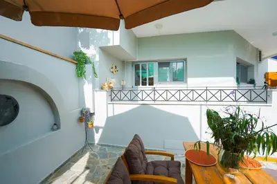 a living room with a glass table and chairs at Moschato modern cozy apartment with private yard in Piraeus