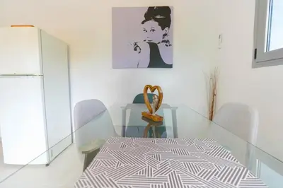 a dining room with a glass table and chairs at Moschato modern cozy apartment with private yard in Piraeus