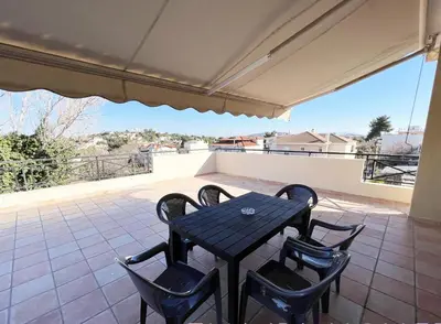 a black table and chairs on a patio at evaxila \u5496\u5561\u5c9b in Glyka Nera