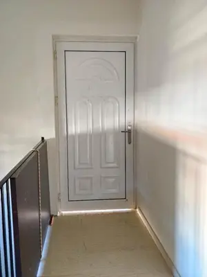 a white door in a room with a staircase at evaxila \u5496\u5561\u5c9b in Glyka Nera