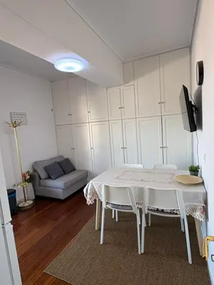 a room with a table and chairs and a couch at evaxila \u5496\u5561\u5c9b in Glyka Nera