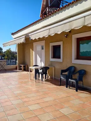 a patio with chairs and a table on a house at evaxila \u5496\u5561\u5c9b in Glyka Nera