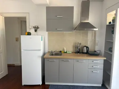 a kitchen with a white refrigerator and a sink at evaxila \u5496\u5561\u5c9b in Glyka Nera