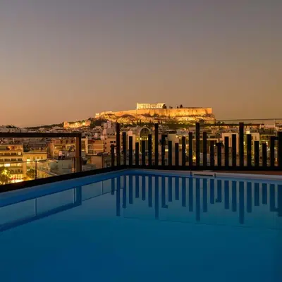a view of the acropolis from a hotel swimming pool at Thea Acropolis Suites & Apartments in Athens