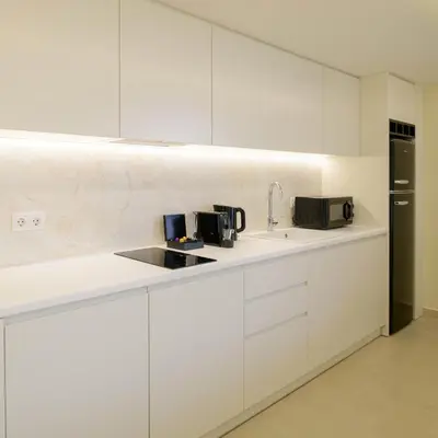a kitchen with white cabinets and a sink at Thea Acropolis Suites & Apartments in Athens