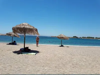 a person standing on a beach with umbrellas at Athens Glyfada Luxury Loft Swimming Pool fully equipped all new in Athens