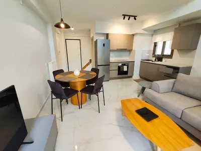 a living room and kitchen with a table and a couch at Athens Glyfada Luxury Loft Swimming Pool fully equipped all new in Athens