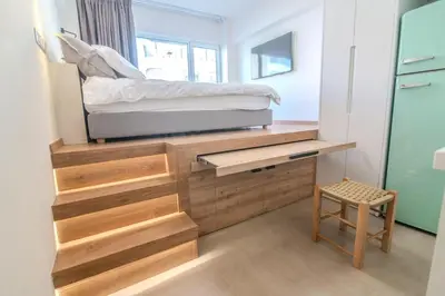 a bedroom with a bed on top of a wooden dresser at Monastiraki Center Stay in Athens