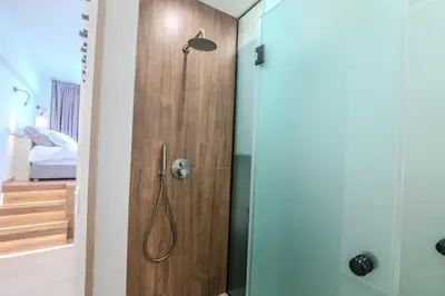 a bathroom with a shower with a wooden door at Monastiraki Center Stay in Athens